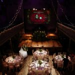 Atmospheric wedding ceremony at Wilton's Music Hall with candlelight and Victorian balconies"