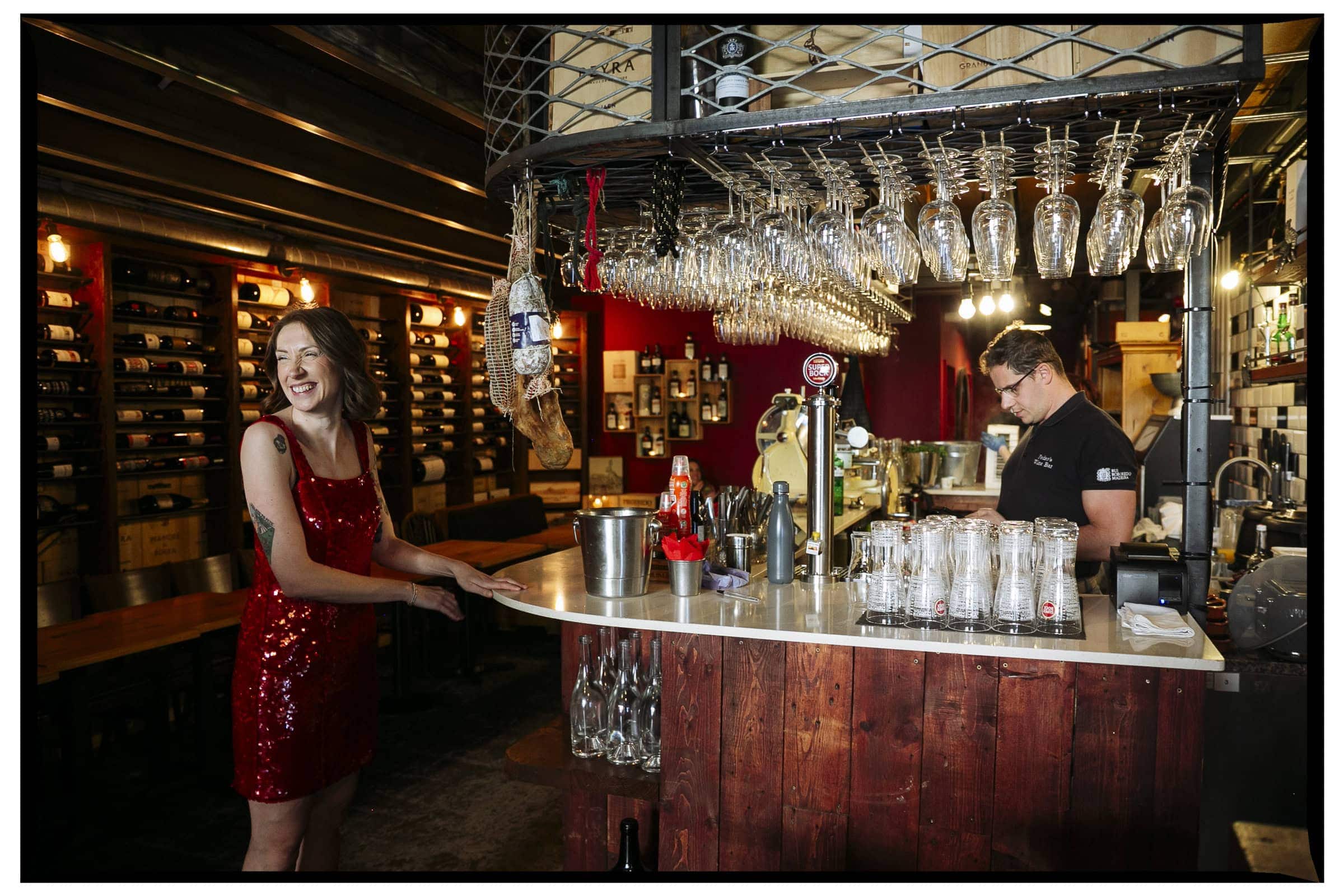 A woman in a red sequinned dress stands at the bar at Pedro’s Wine Bar