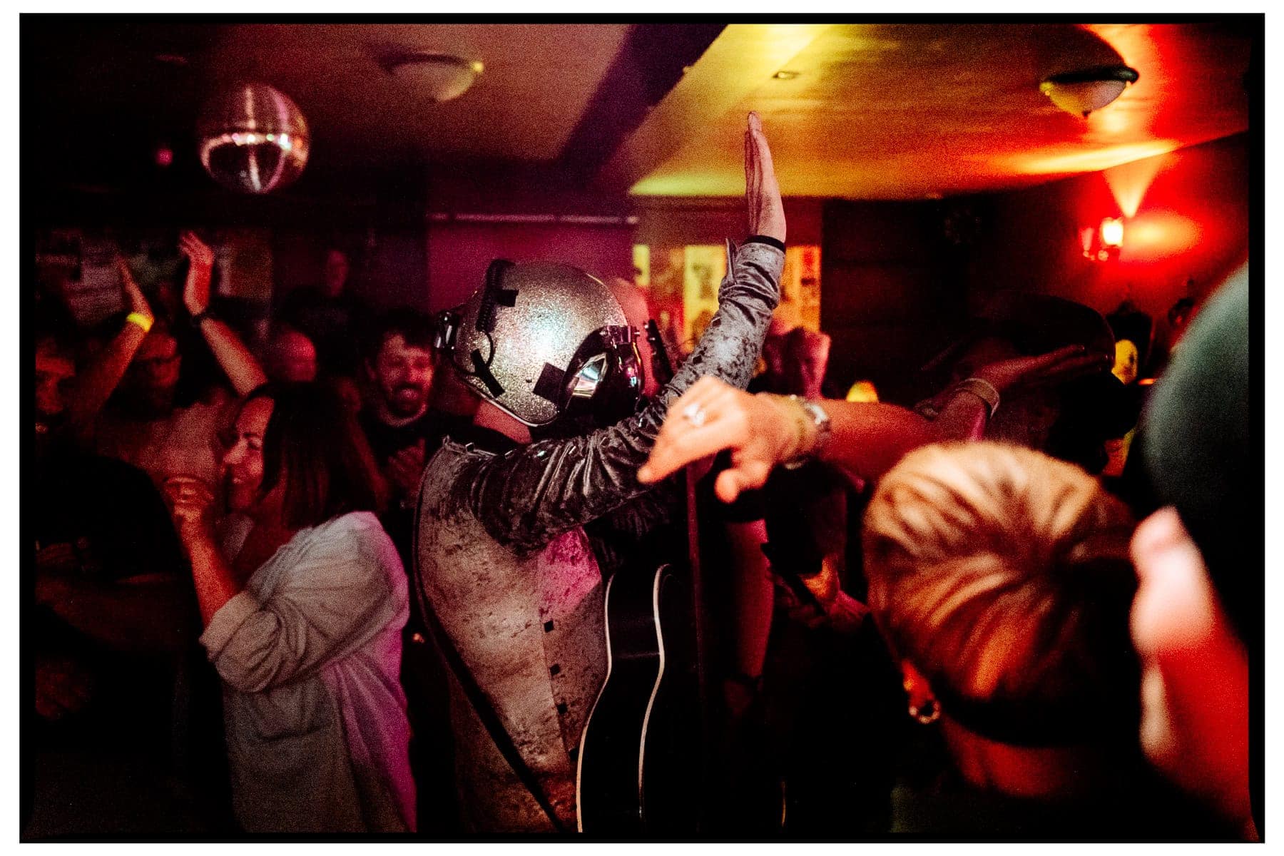 Close-up documentary photograph of Bob Log III performing among the audience at The Piper