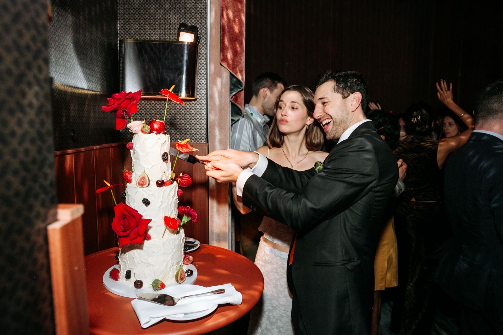 A couple cuts a cake at a lively reception