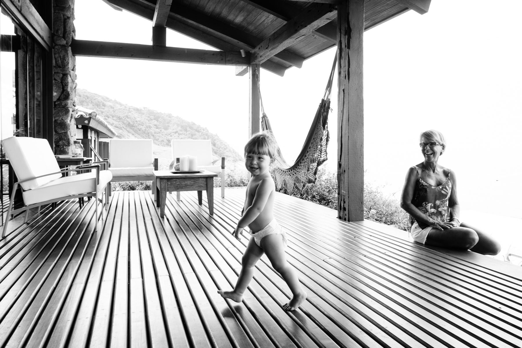 A child moves across a slatted terrace in a black-and-white photograph