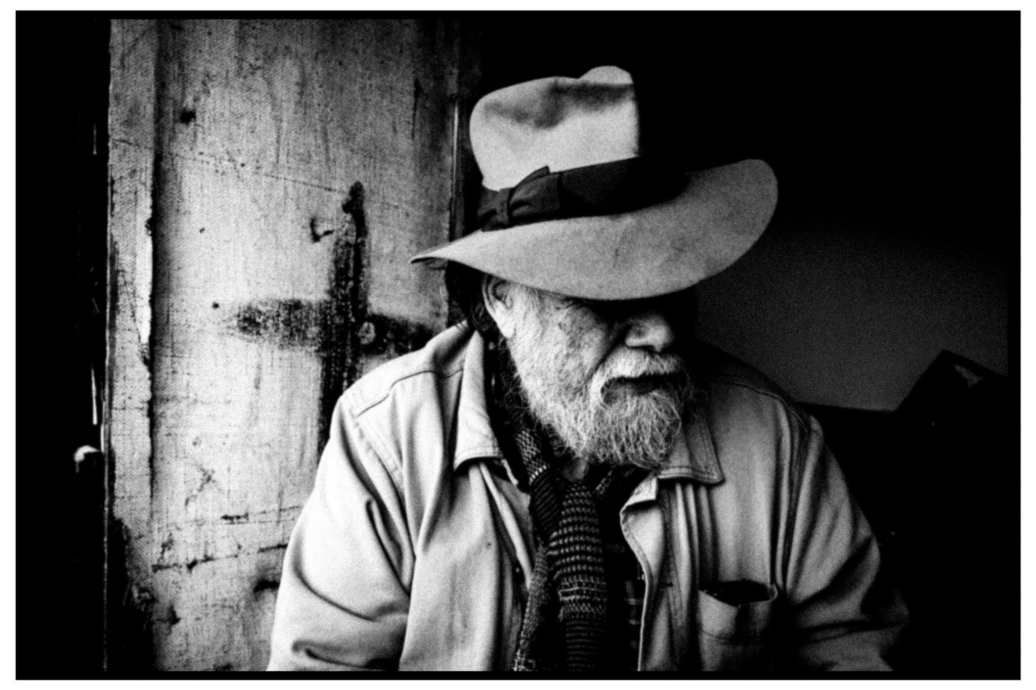 Foxtrot Echo of COUM Transmission seated at home, with his eyes shaded by a wide-brimmed hat.
