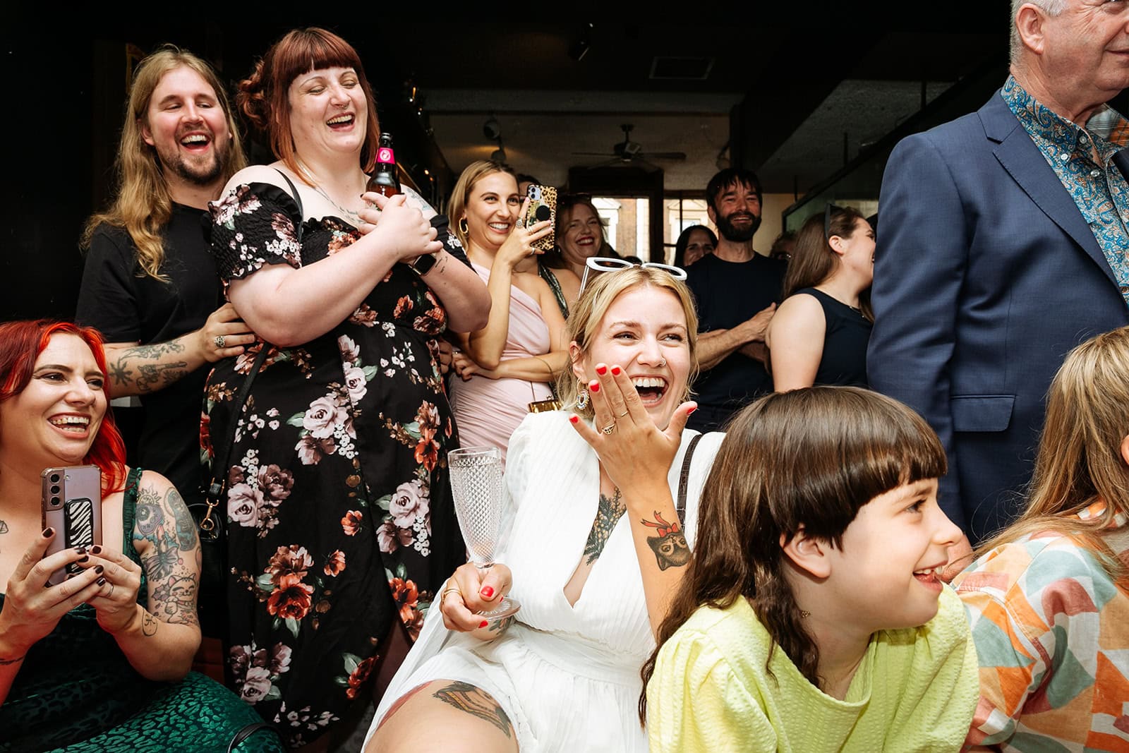 A bride laughs among a crowd of guests at her North London wedding