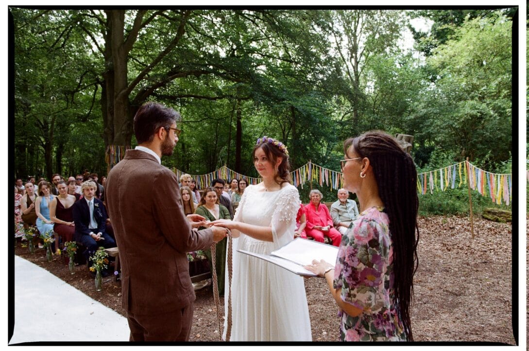 The couple holding hands during their Wellington Wood ceremony