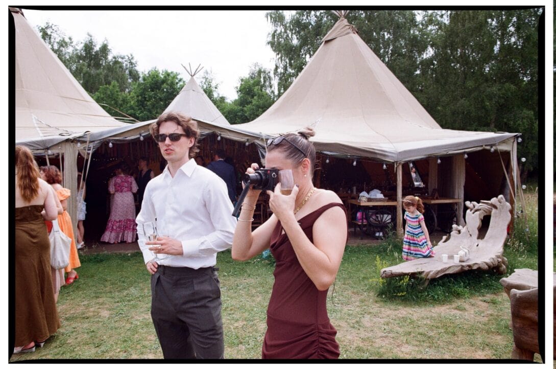 A wedding guest photographing the reception on film