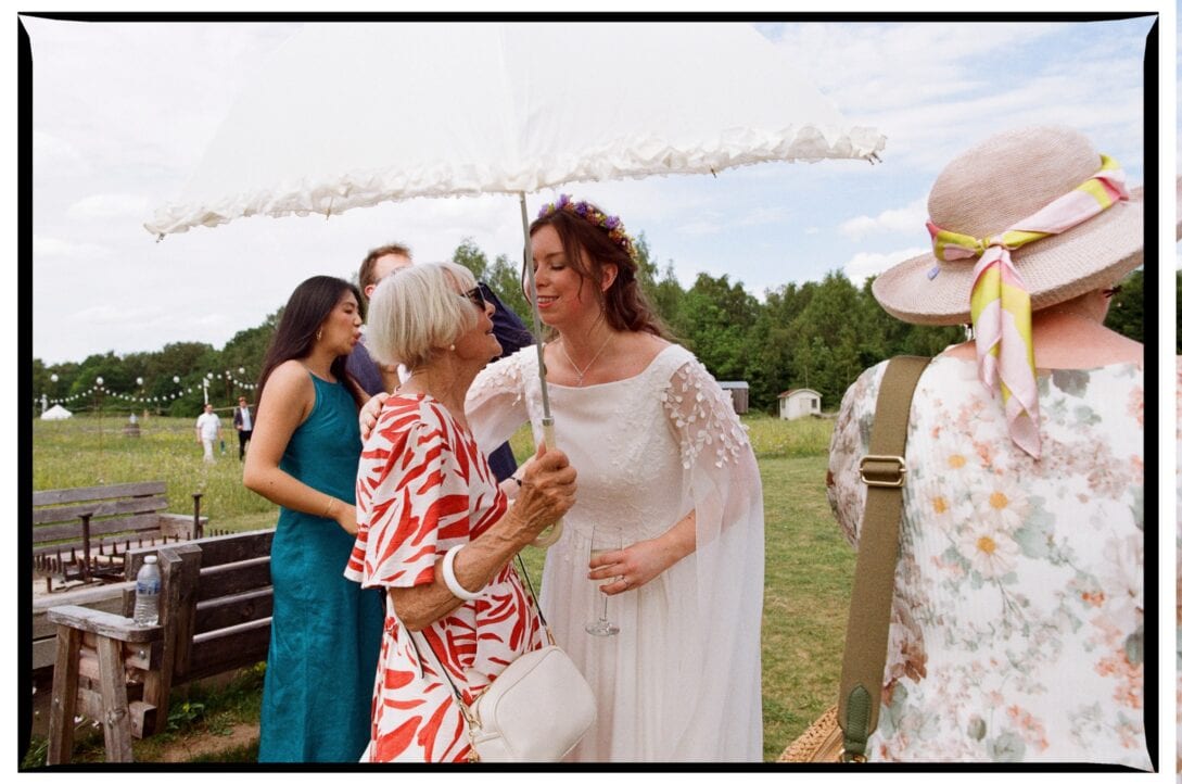 Zoe talking with guests beneath a parasol
