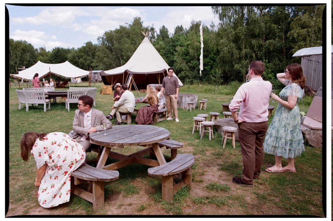 Wedding guests talking around picnic tables