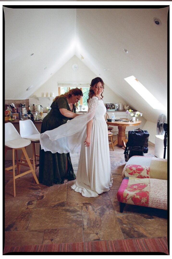 A friend adjusting Zoe’s wedding dress before the ceremony