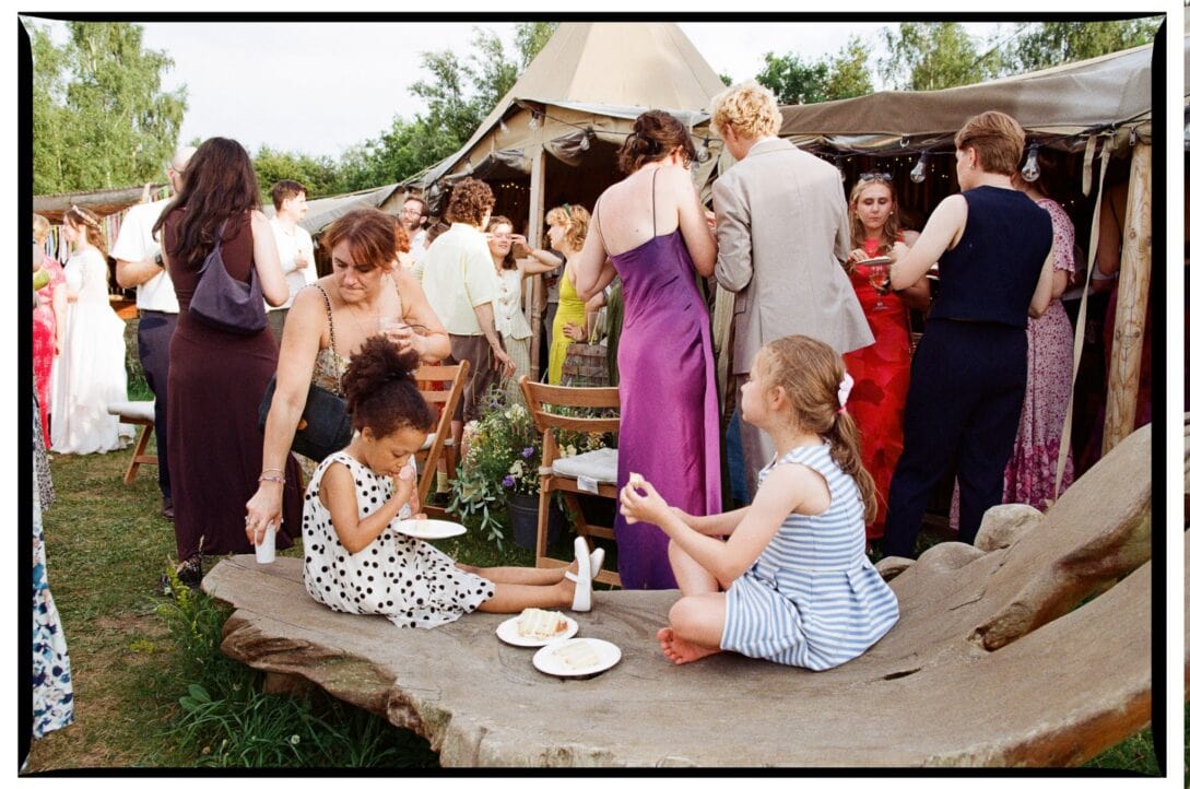 Children eating on a wooden bench during the reception