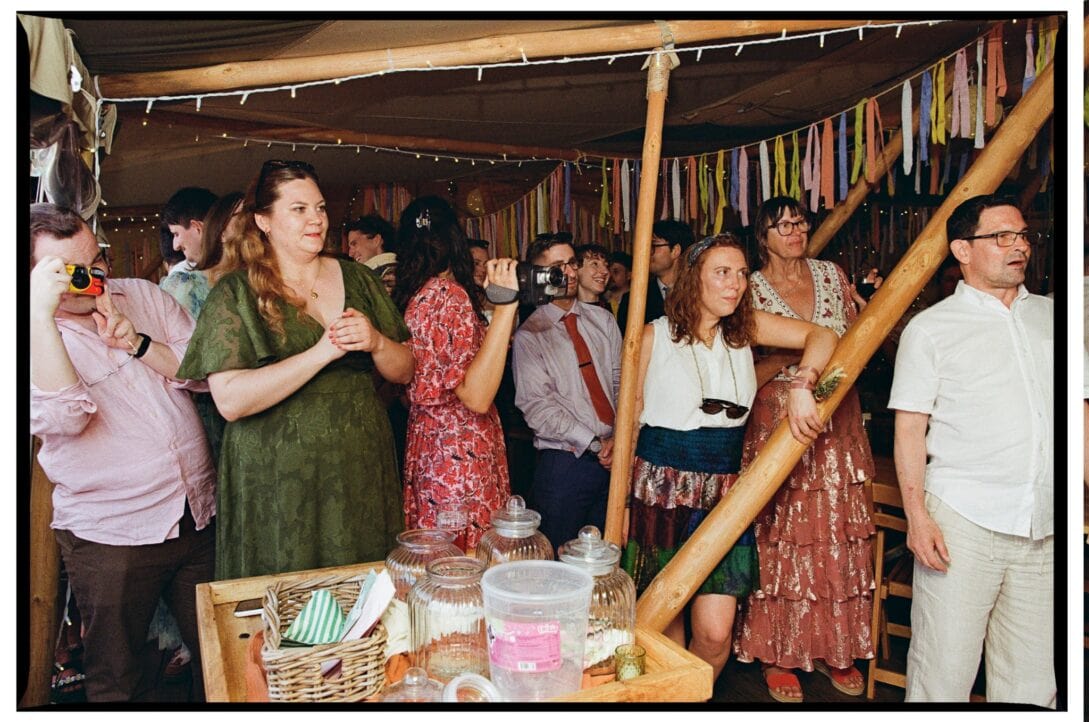 Wedding guests gathered inside the decorated canvas tent