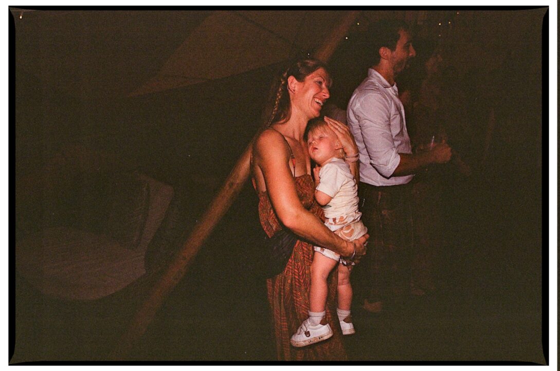 A guest dancing while holding a sleeping child