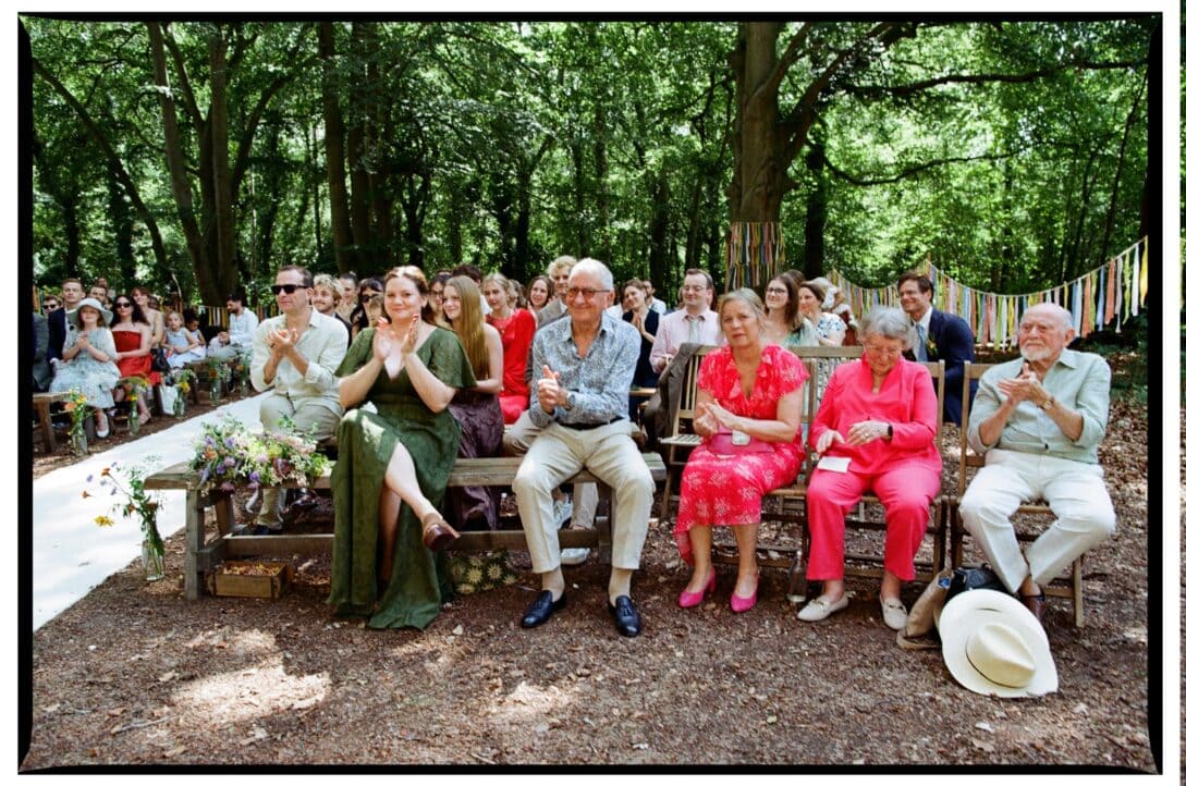 Wedding guests applauding during the woodland ceremony
