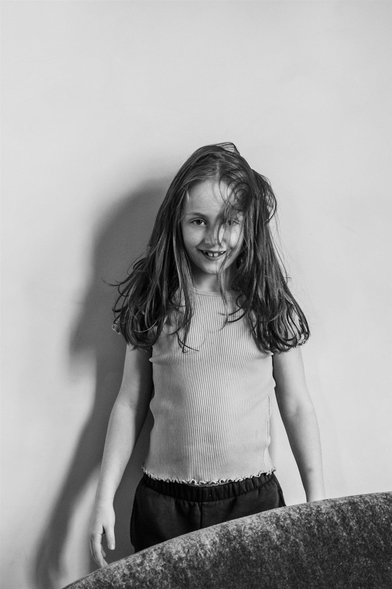 A young girl looks straight at the camera in a quiet portrait