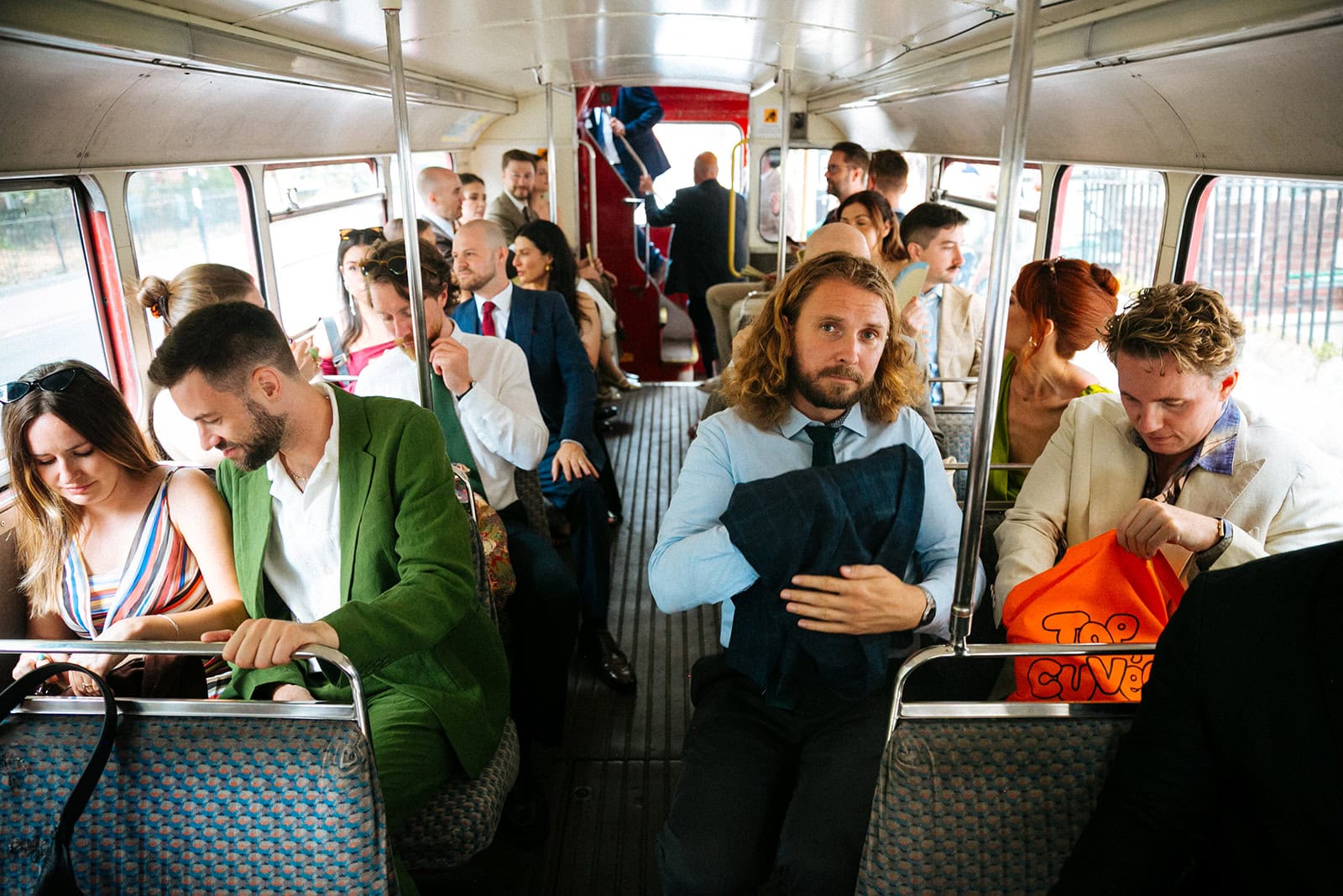 Wedding guests aboard a bus to St John in Clerkenwell