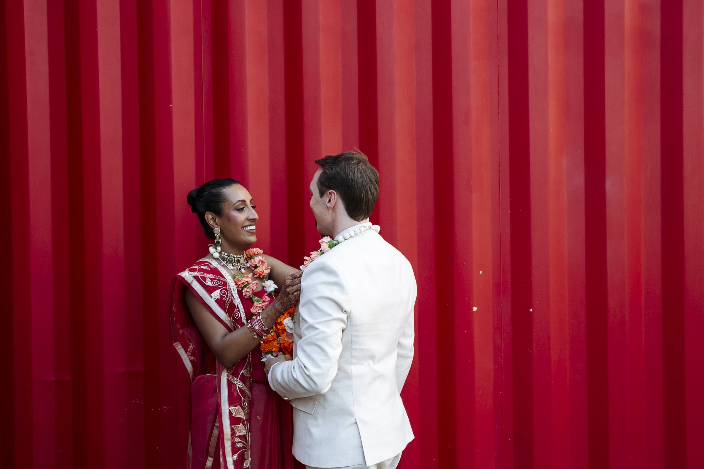 Alex and Fayjel facing each other against a red shipping container