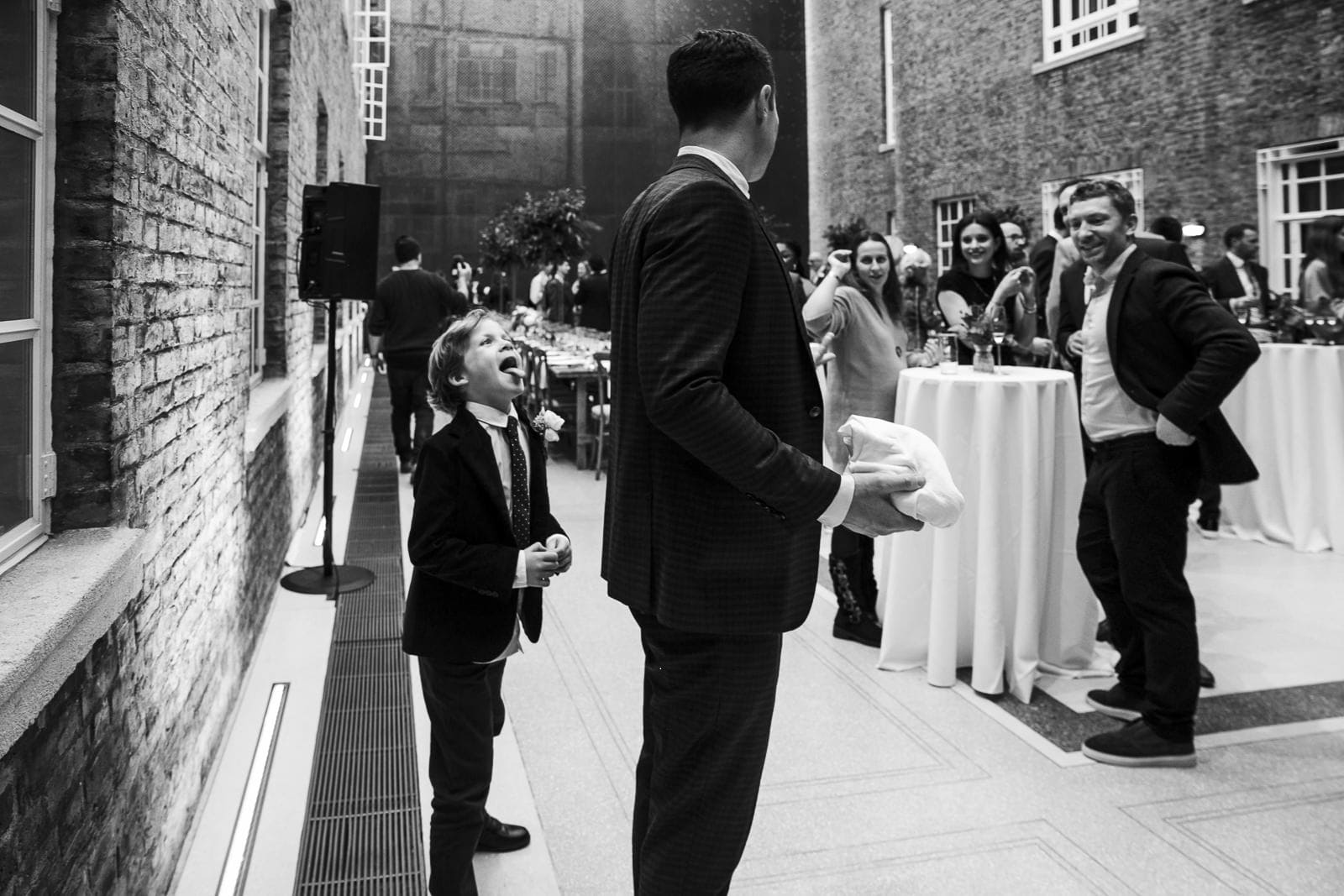 A boy laughing with guests at the reception