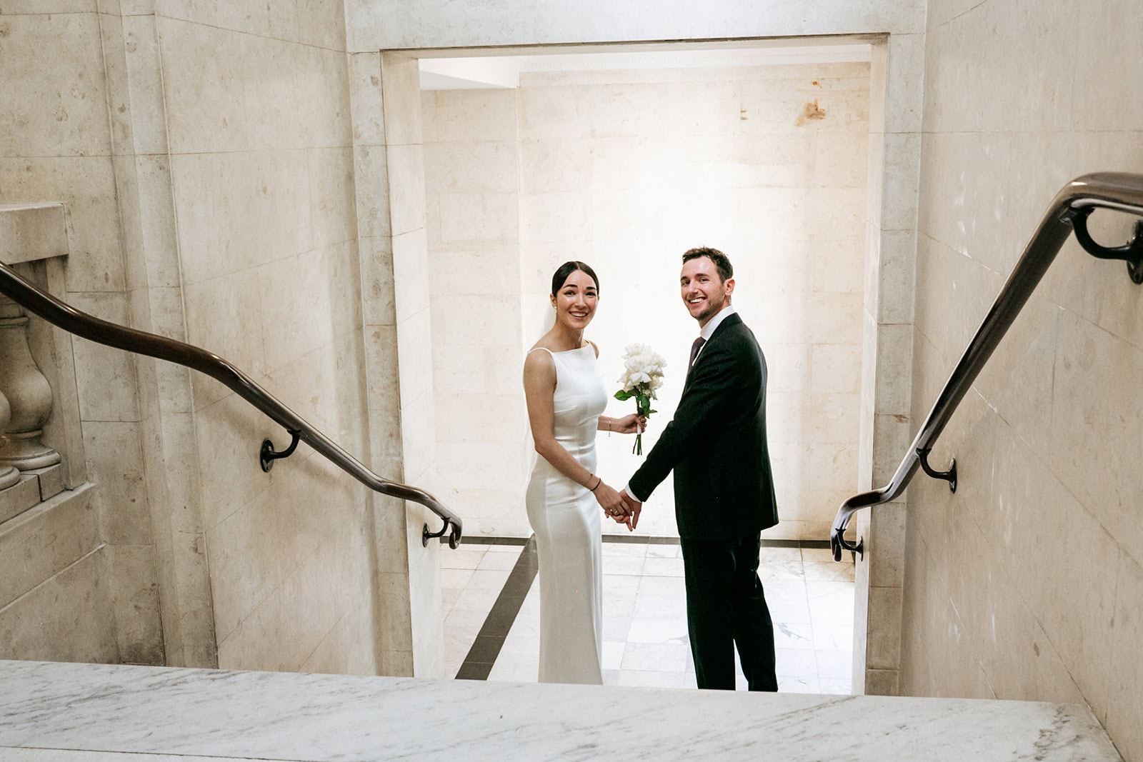 Paula and Pascal holding hands on the town hall staircase