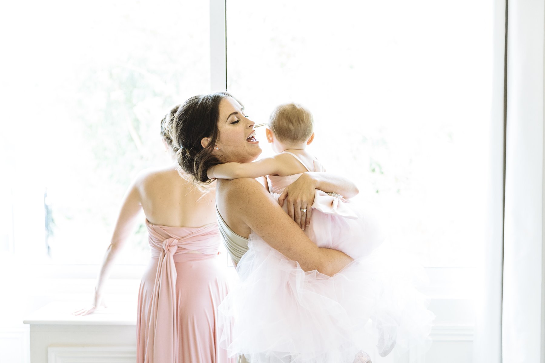 A young bridesmaid holding a child