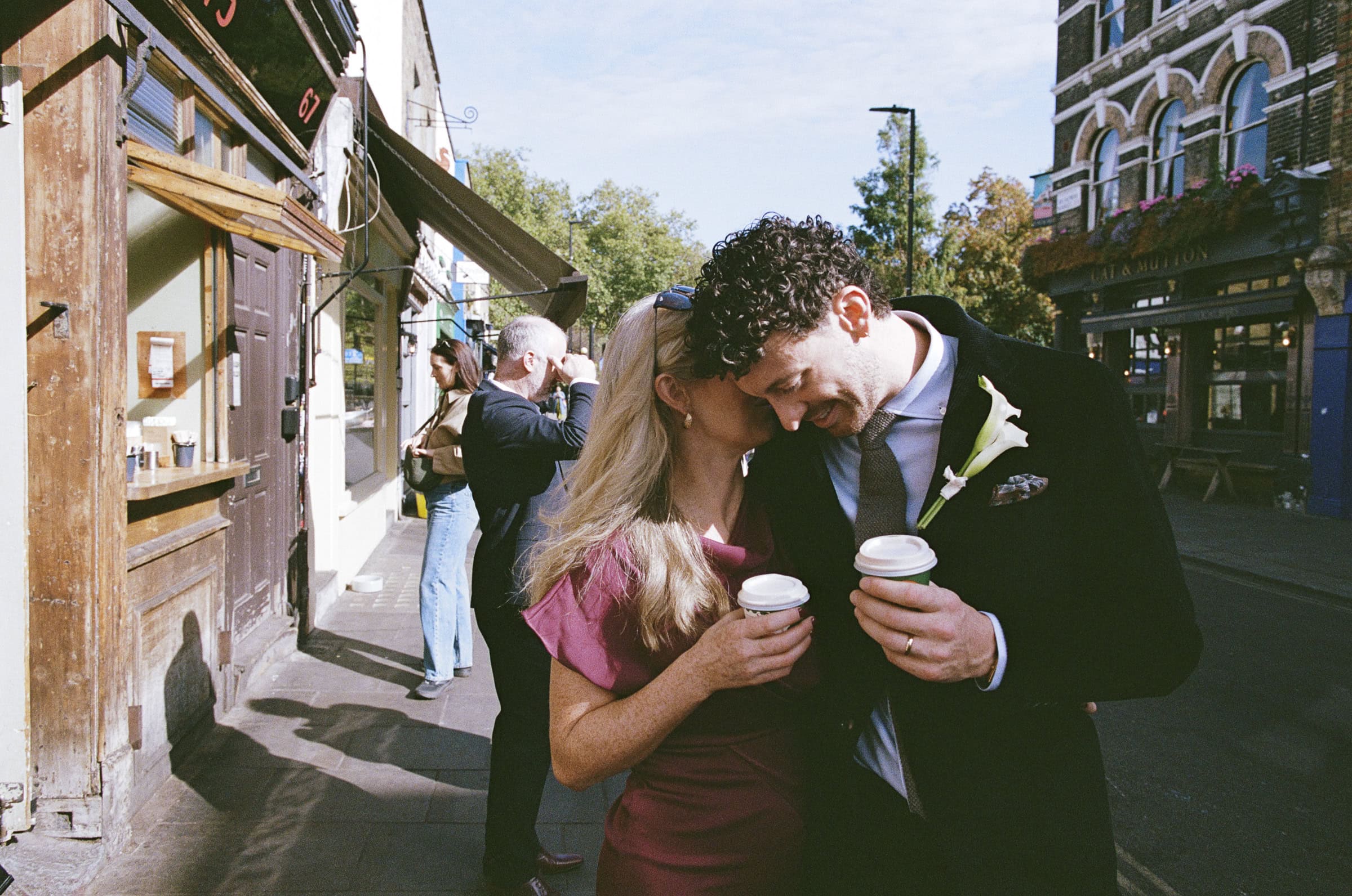 A groom embracing a family member outside the coffee shop